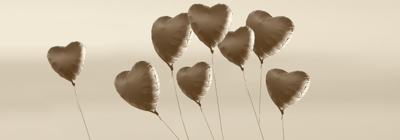 Acht herzförmige Luftballons vor ruhigem Himmel als Ausdruck von Herzlichkeit, Dankbarkeit und einer besonderen Geschenkideen